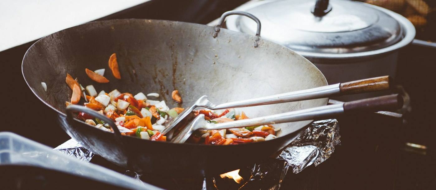 Groente in een stalen wok op een gasbrander