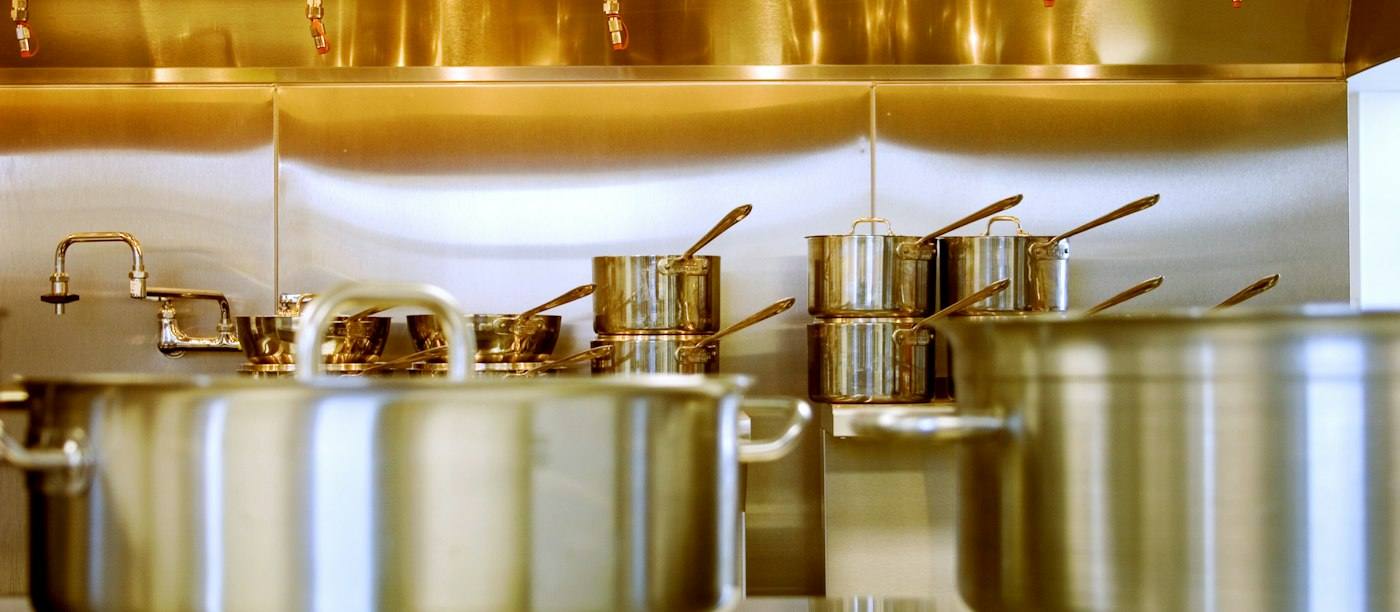 Een rij RVS pannen in een professionele keuken