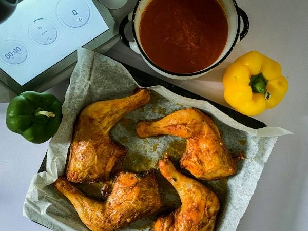 Kip op bakpapier naast een keukenapparaat